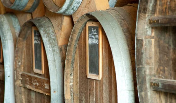 Tonneaux et fûts de calvados dans le chai de vieillissement d'une distillerie du Calvados