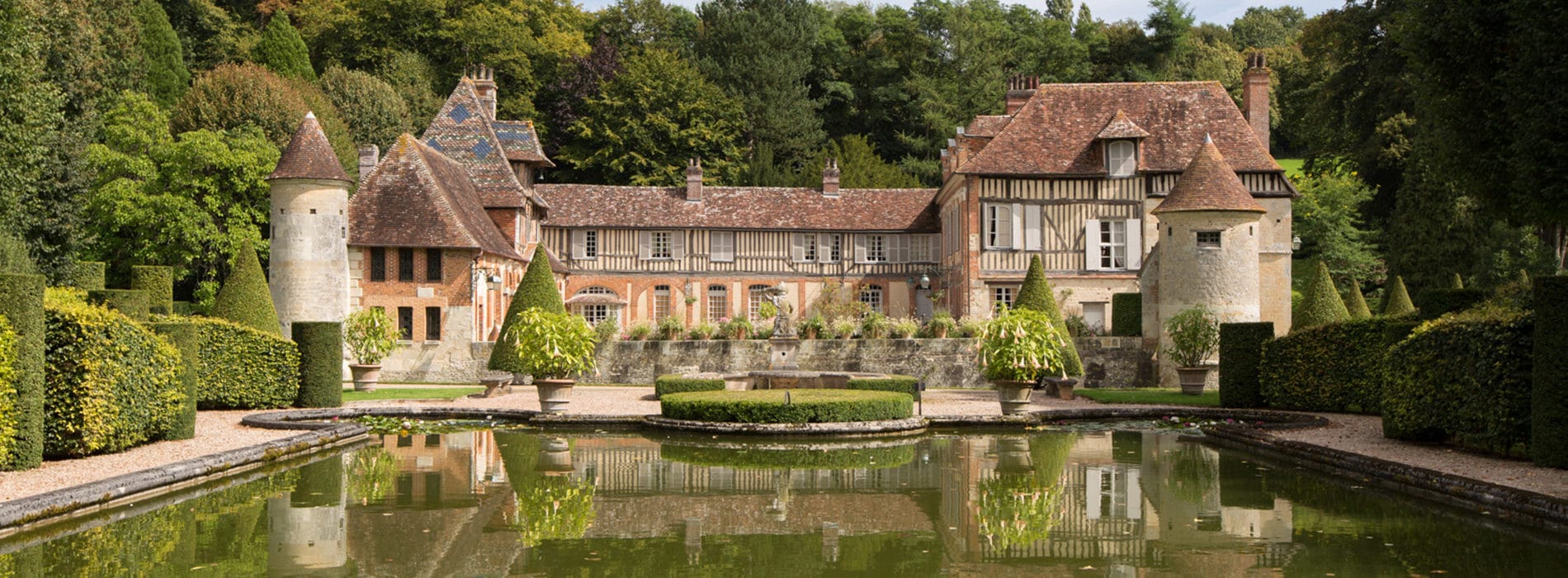 manoir à colombages avec pièce d'eau en premier plan