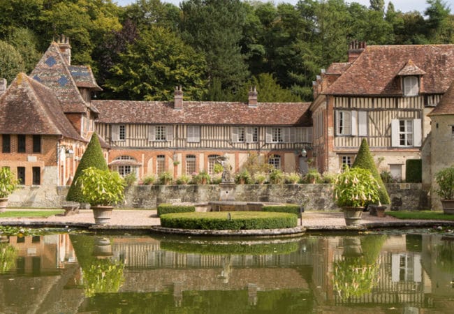 manoir à colombages avec pièce d'eau en premier plan