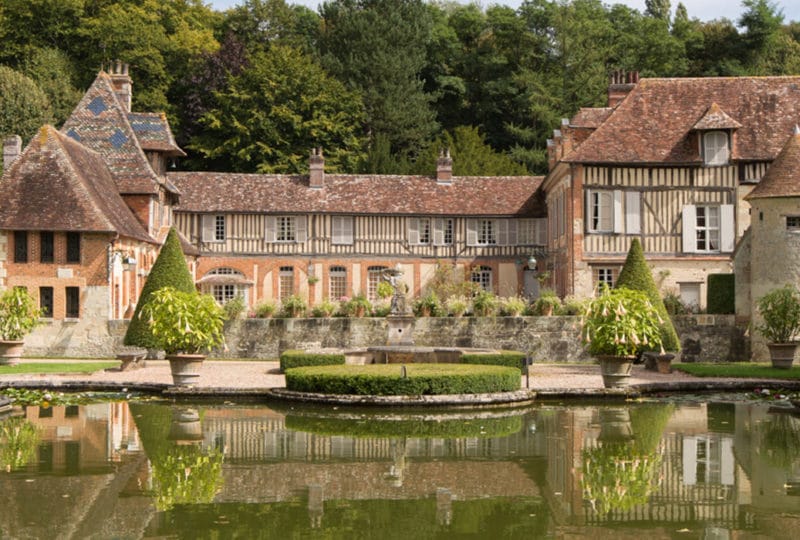 manoir à colombages avec pièce d'eau en premier plan