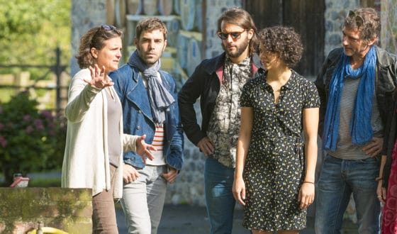 personnages écoutant le guide pendant une visite guidée en extérieur
