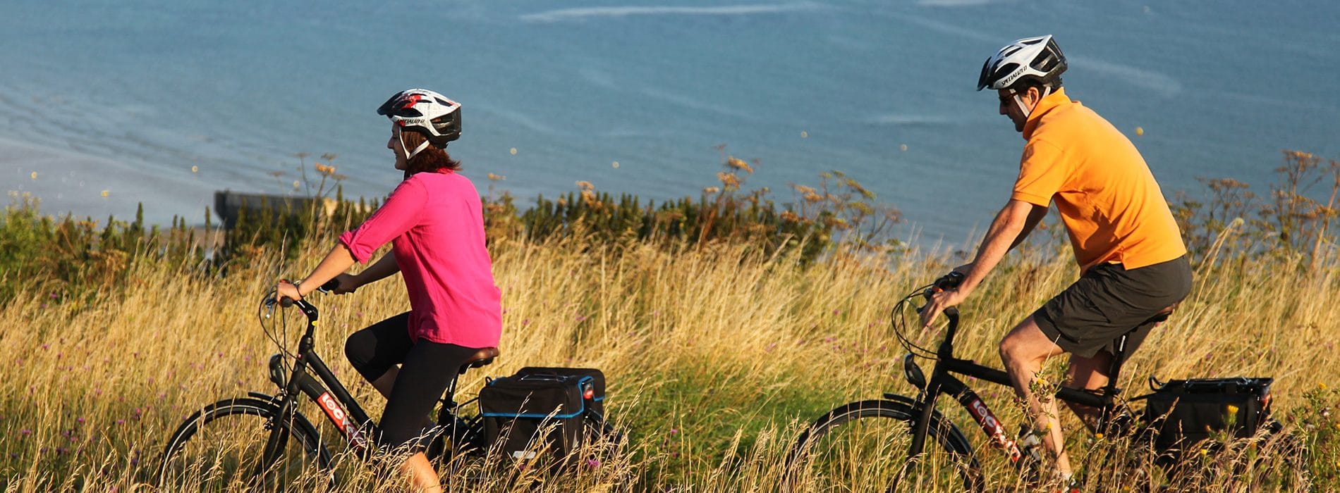 Couple en balade à vélo le long du littoral