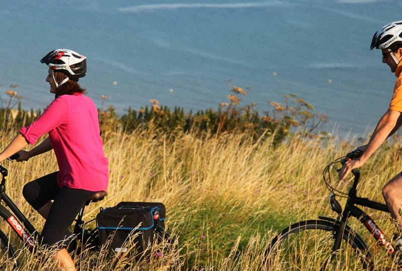 Couple en balade à vélo le long du littoral