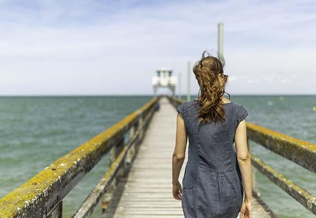 Femme marchant sur la jetée à Luc-sur-mer