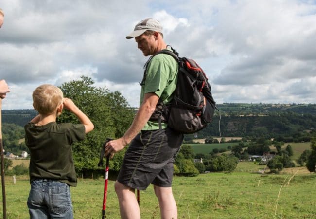 couple avec enfant en randonné pédestre dans des champs