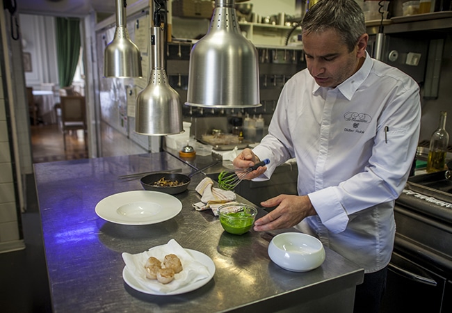 Chef cuisinier dans sa cuisine préparant une recette