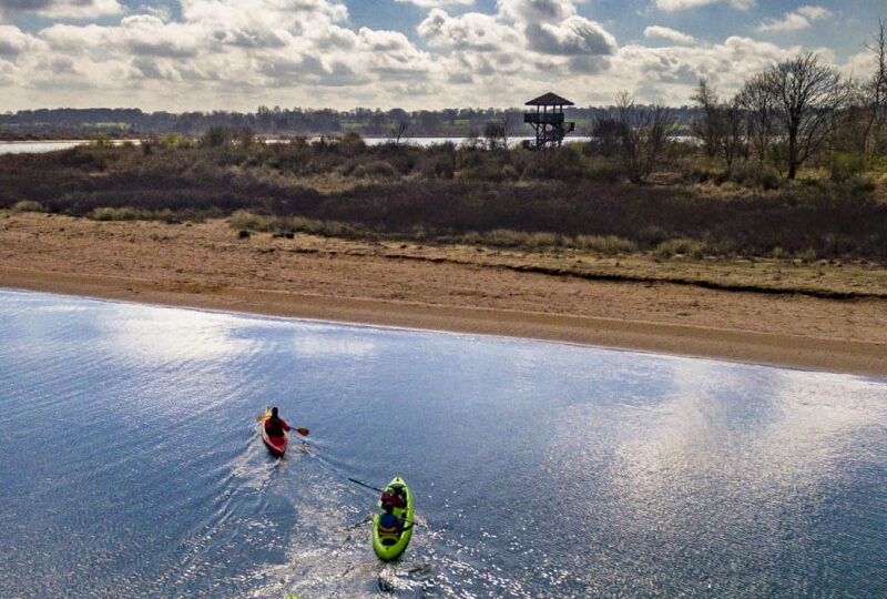 Deux kayaks en mer dans la baie de l'Orne avec une vue sur l'observatoire de Ouistreham