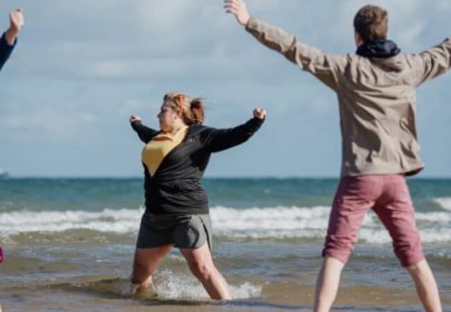 personnes pieds dans l'eau sur la plage