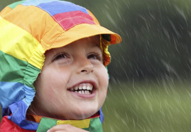 enfant en k-way multicolores sous la pluie